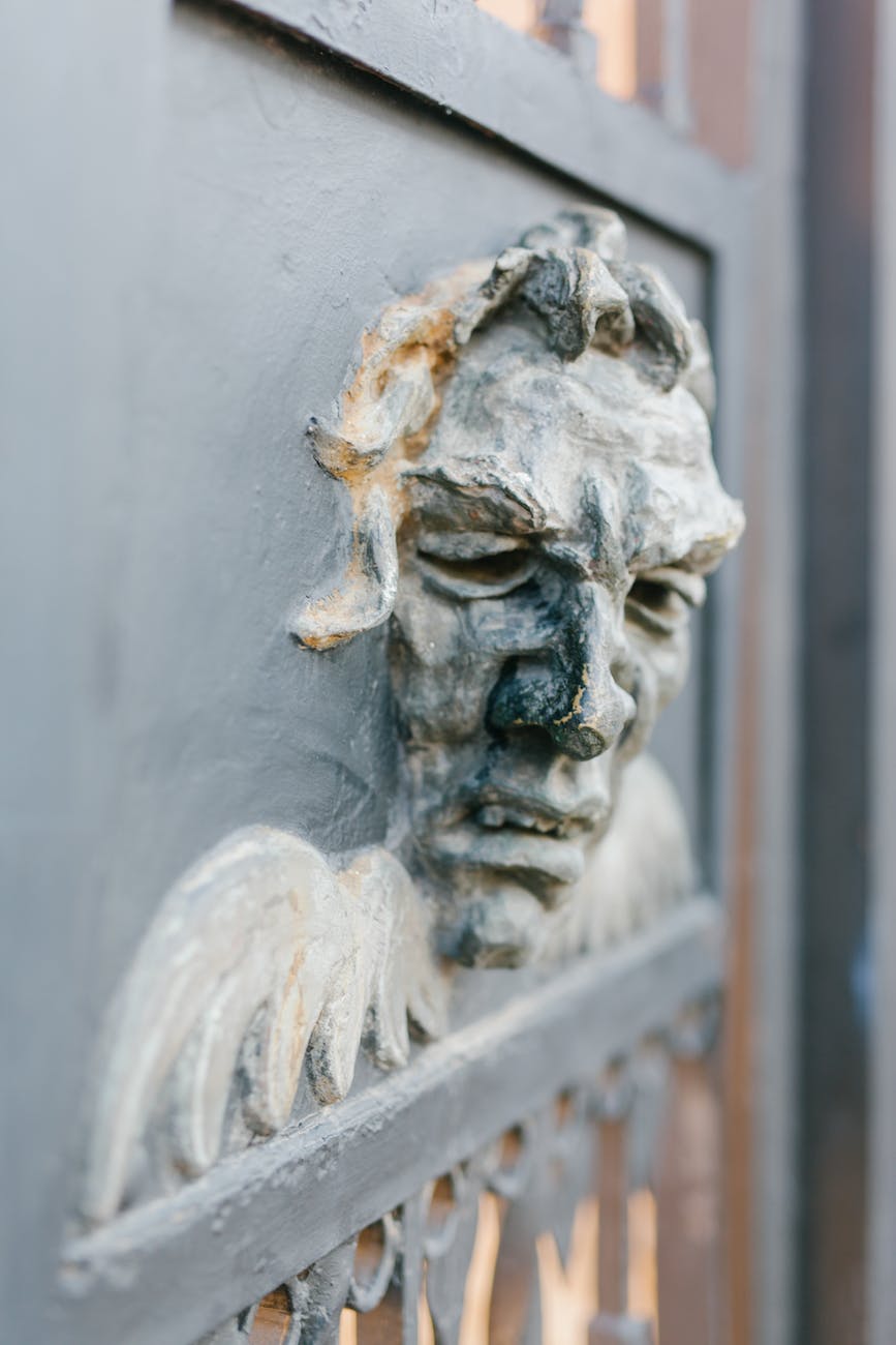 stone mascaron on old gate with ornament