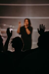 silhouette of people raising their hands